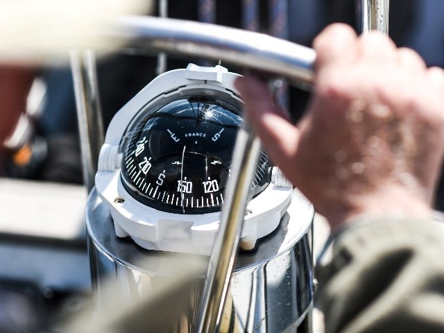 A compass, a view from above the steering wheel on a yacht.