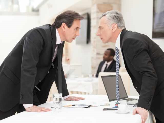 Two businessmen arguing over who owns an AI project
