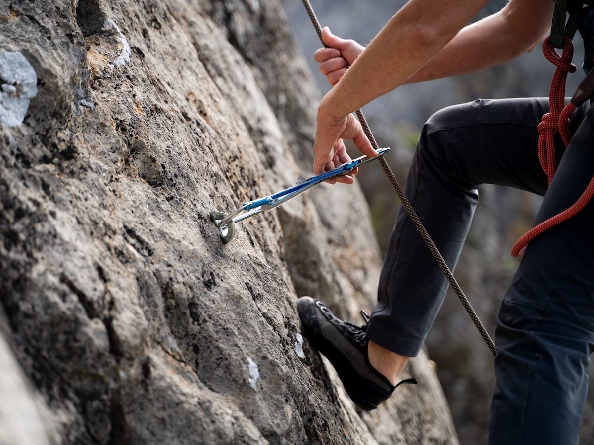 climber removing quickdraw from bolt during top rope descent