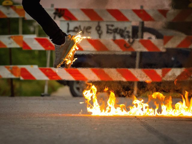 person jumping in air with sneakers on fire