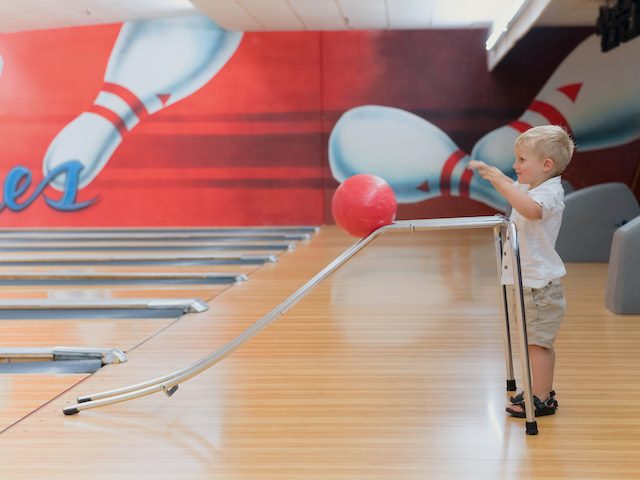 trainer in a bowling alley, guiding where the bowling ball will go