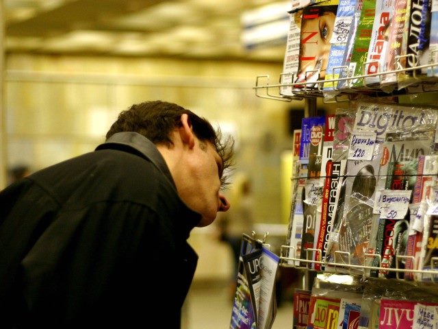 A man looking into a magazine stand.