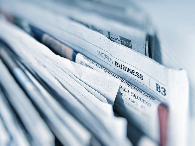 The sections of a newspaper folded together.