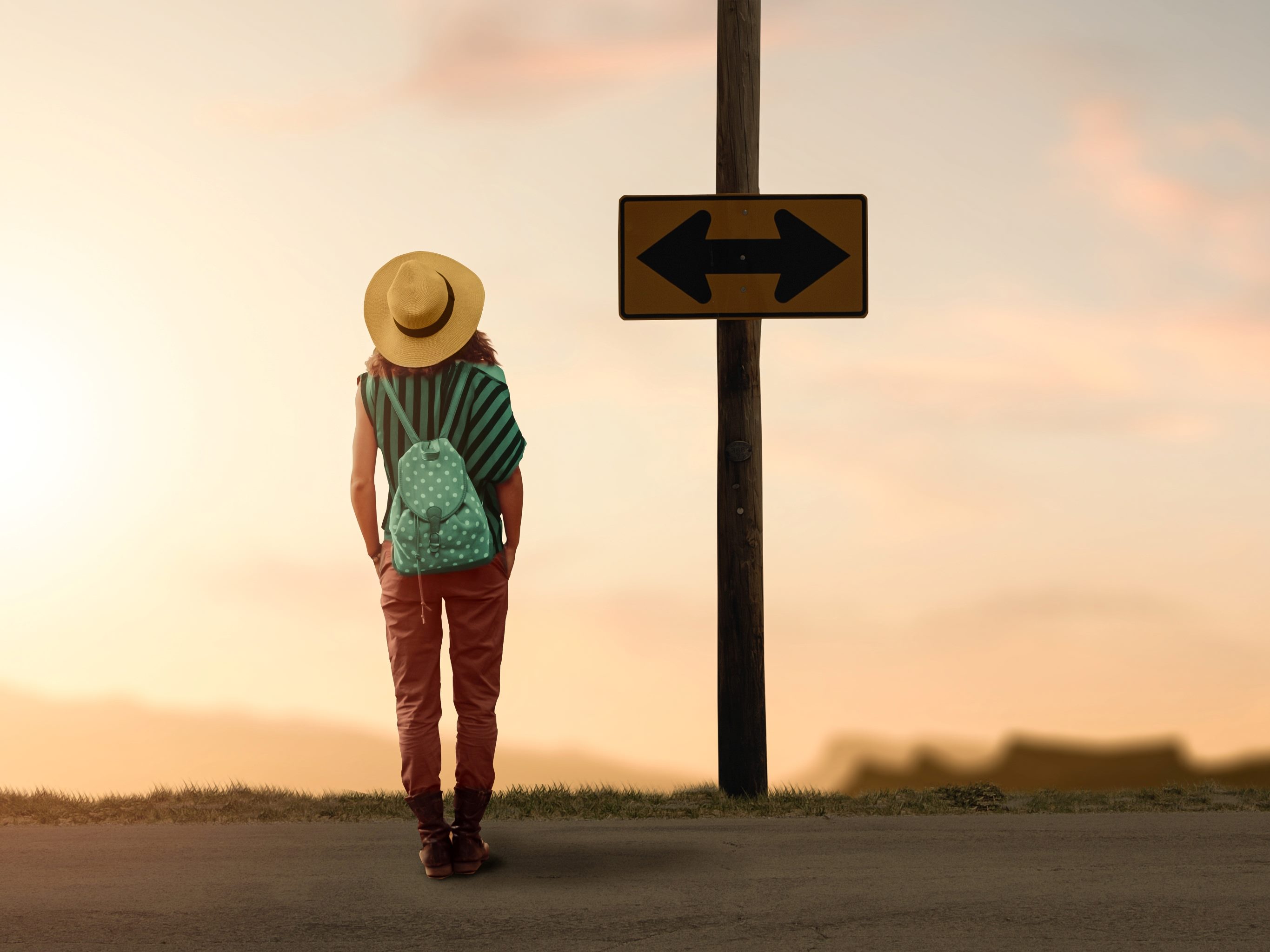 A backpacker woman traveler wondering for a way to go as she looks at a sign with arrows pointing to the left and right.