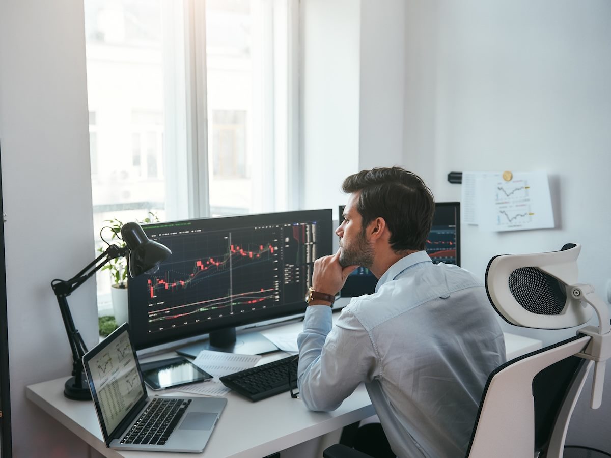 a person looking at data on computer screens