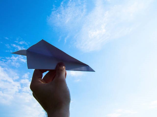paper airplane against a blue sky