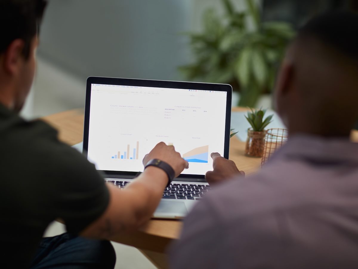 two colleagues reviewing data visualizations on a laptop