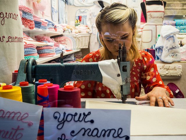 A women personalizing bags, aprons, towels and other items in Venice by Alex Hesse
