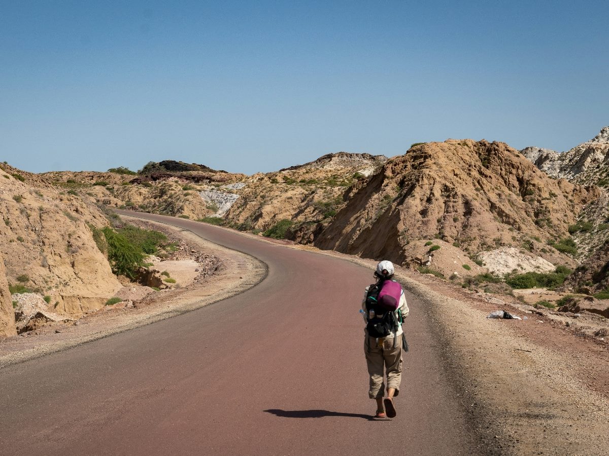 Woman walking forward on an empty road.