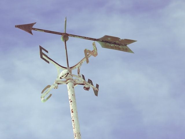 White weather vane against blue sky