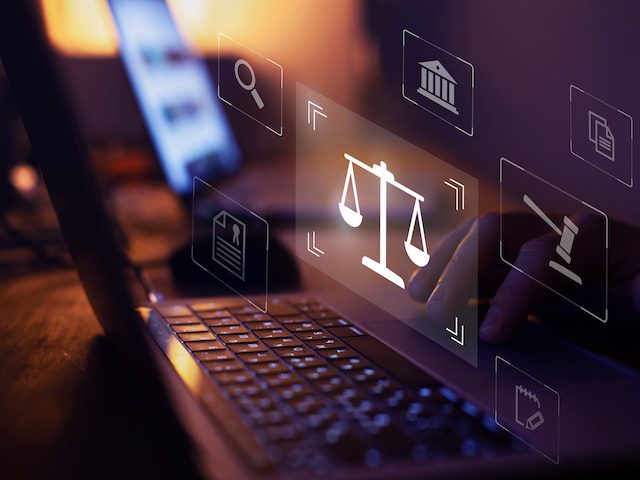 laptop with hologram of scales of justice