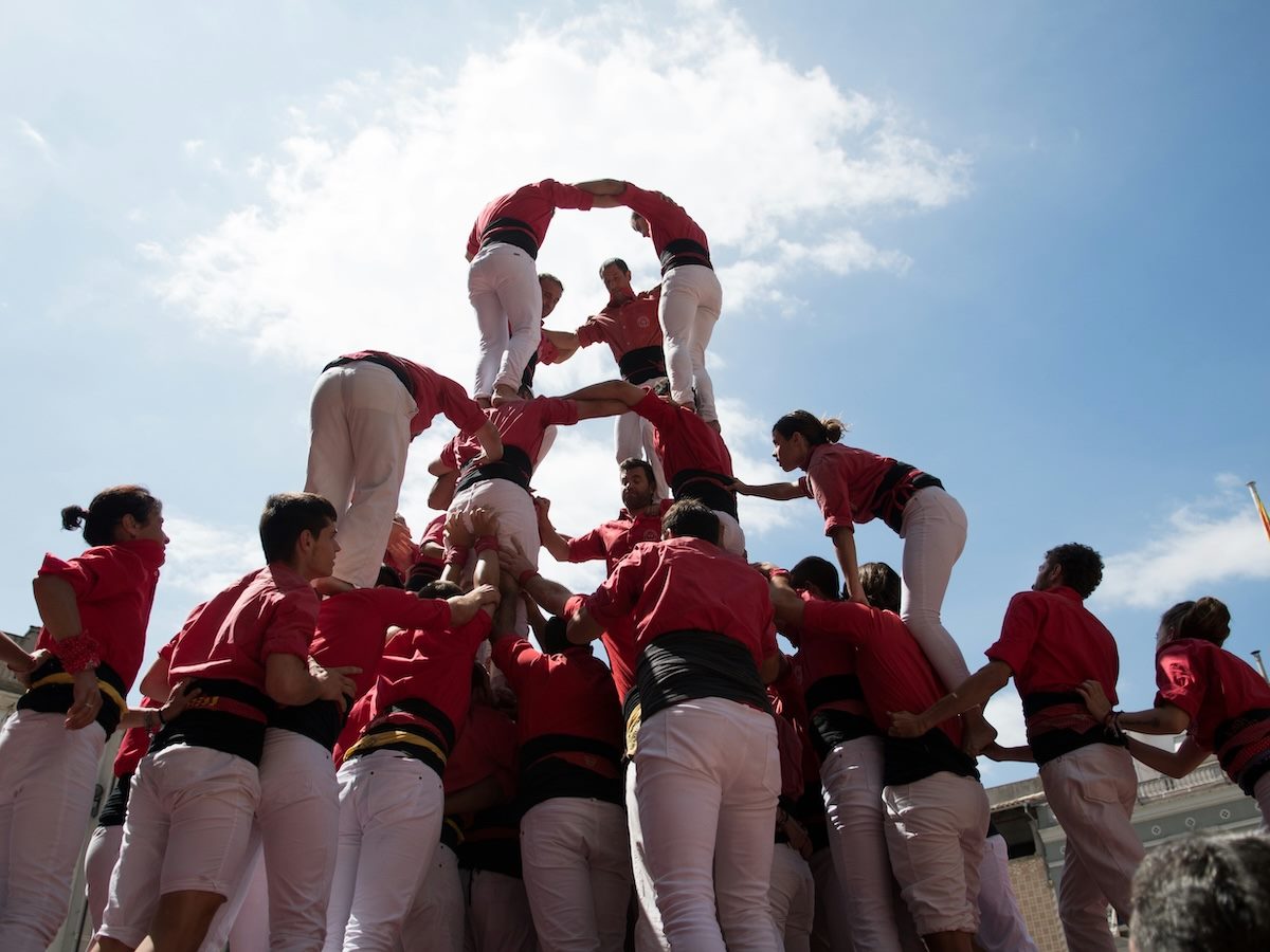 forming a pyramid of people with a wide base and narrowing to the top. 