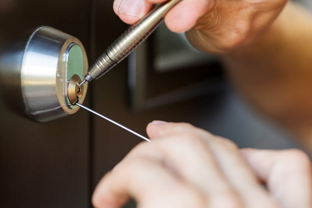 A close-up view of a person using a lock picking tool on a door lock, demonstrating the complexity and precision necessary for successful AI integration in enhancing customer service operations.