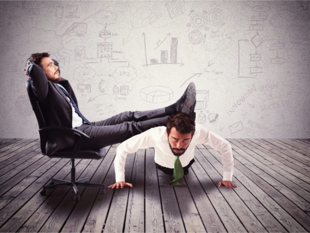 Man in a chair with feet on a man's back, who is doing push ups. AI's impact on marketers