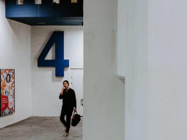 person walking through a parking garage talking on a cell phone