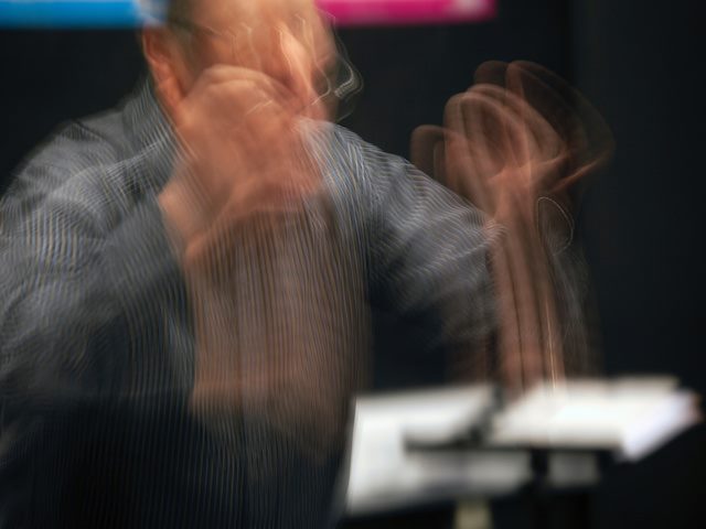time lapse photograph of a conductor in motion