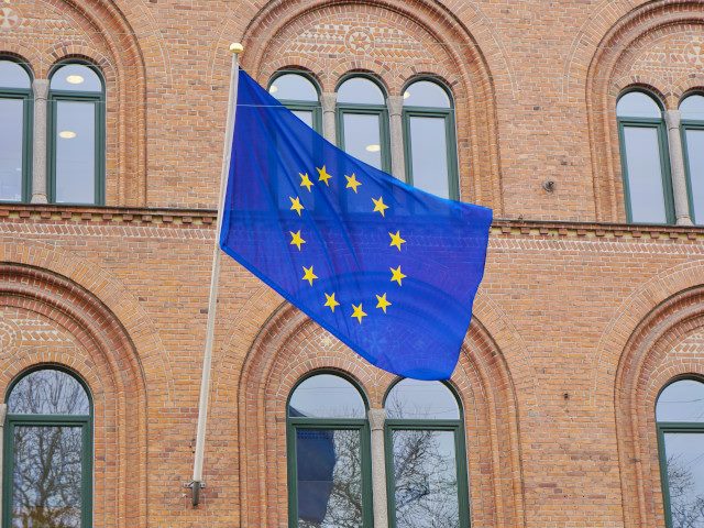 The EU flag hangs on a building.
