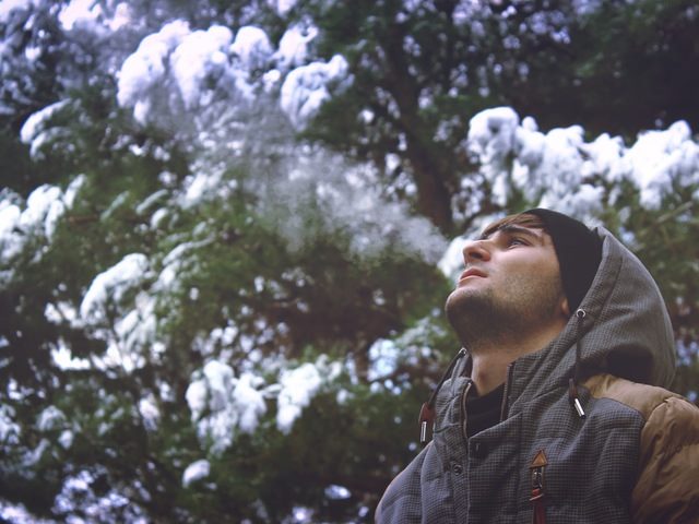 young man looking up in a forest