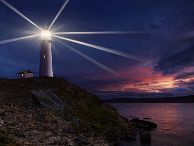 Lighthouse with light shining at night.