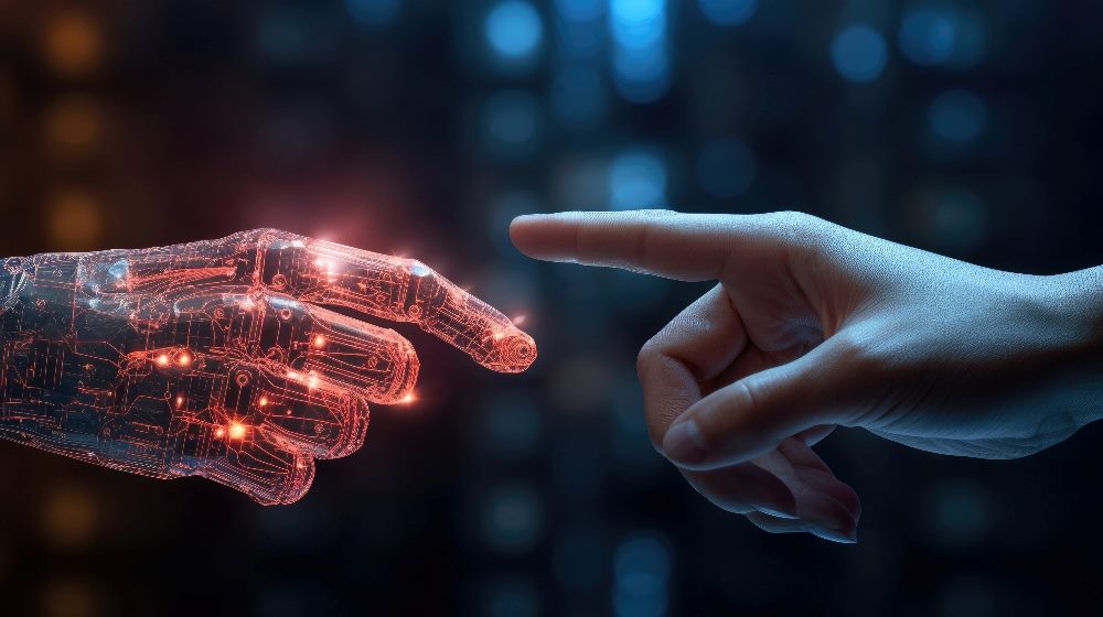 The human finger delicately touches the finger of a robot's metallic finger, indicating the concept of harmonious coexistence of humans and AI technology as the use of generative AI tools continues to rise. 