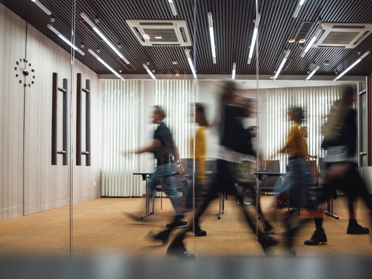 people walking briskly in an office. concept of action, urgency