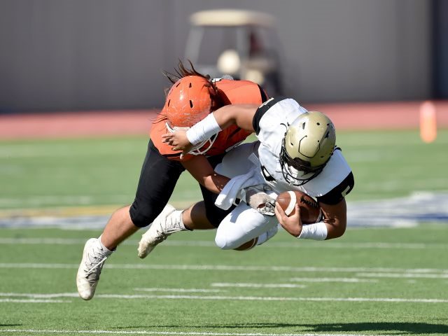 A football player making a tackle during a game - tackling challenges concept