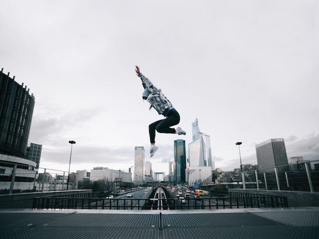woman jumping in air with arms over her head