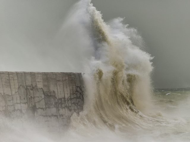 Waves crashing into a sea wall during a windy winter storm at Newhaven on English coast.