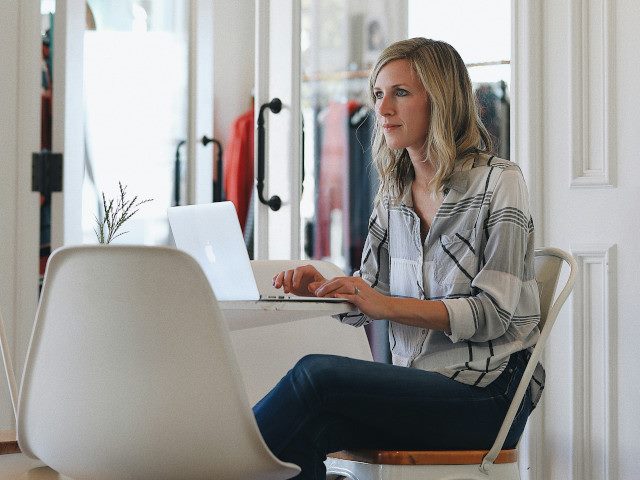 An employee works on a laptop computer in a home office.