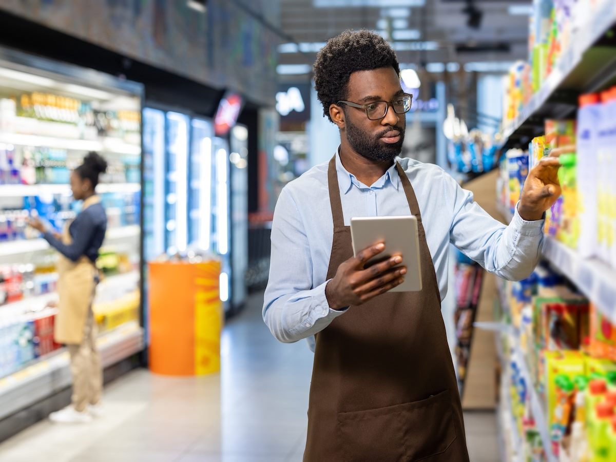 Retail worker holding a digital tablet while performing inventory management