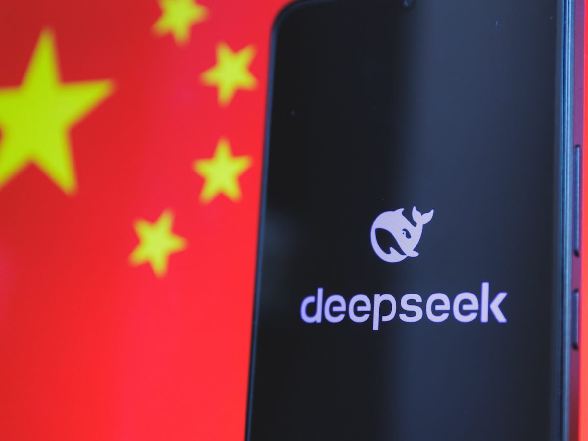 A smartphone displaying the Deepseek logo with the Chinese flag in the background