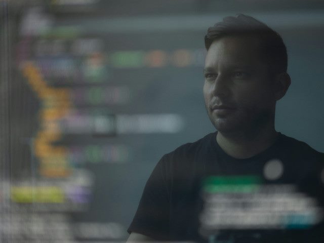 An employee looks at software code on a computer monitor.