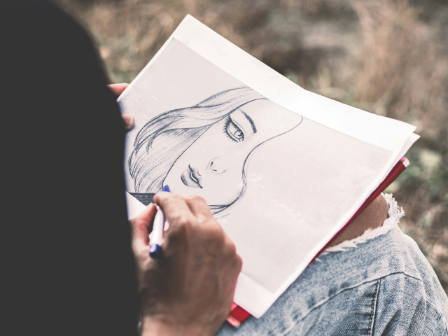 An artist draws a person on a paper.