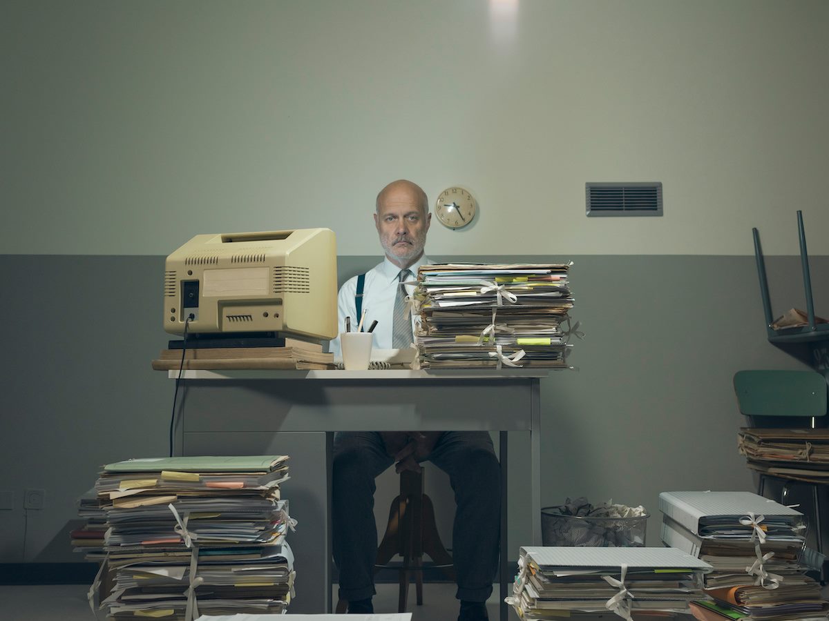 Frustrated businessman overloaded with paperwork