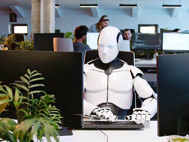 Robot in office typing on keyboard. 