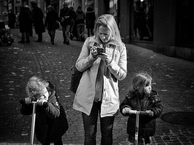 woman with children, using cell phone
