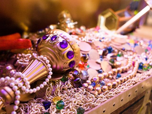 Gold and gemstone treasures hidden in an attic, including a golden scepter with purple gemstones and strands of pearls, symbolizing the hidden treasures of dark data.