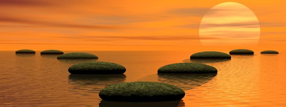 Stones in a body of water outline two diverging paths with an orange sunset in the background, suggesting how AI-based Next Best Action can help decision making.