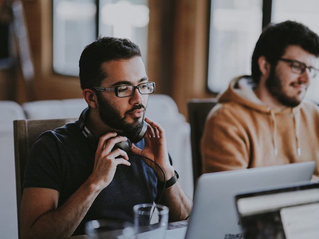 two men working side by side on computers