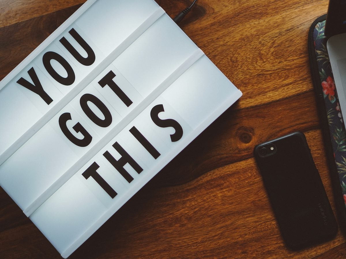 sign on a table with "You Got This" written on it, next to a cellphone