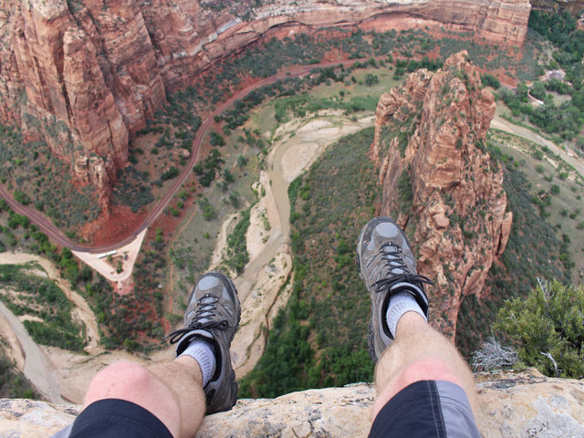 First person perspective shot from a hiker sitting at the edge of a cliff