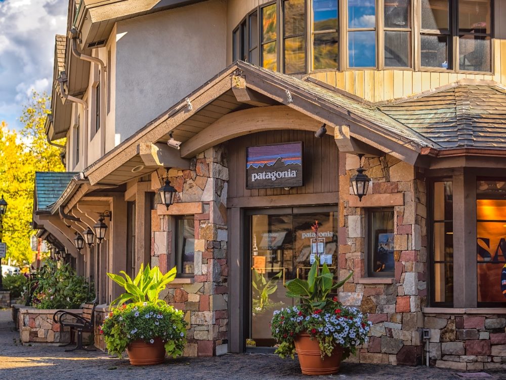 Exterior of a Patagonia retail store with stone facade and potted plants at the entrance.