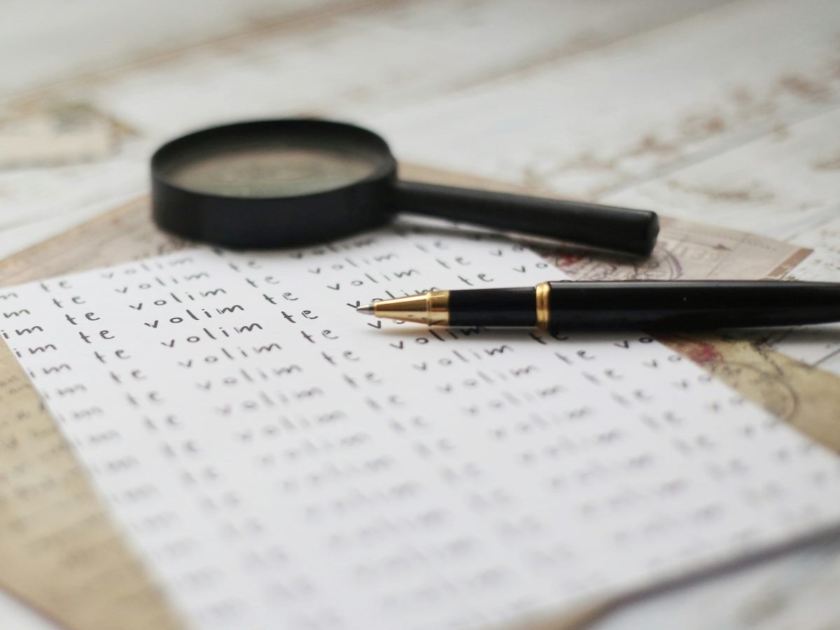 Magnifying glass on top of papers showing numbers.