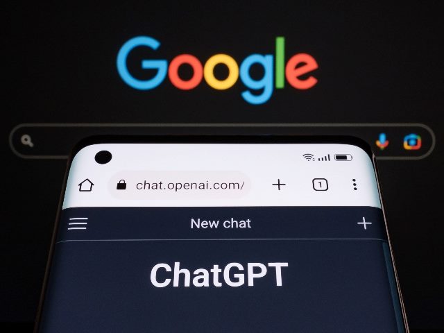 ChatGPT chatbot page seen on a smartphone in the foreground with a laptop display with blurred GOOGLE search page in the background. 