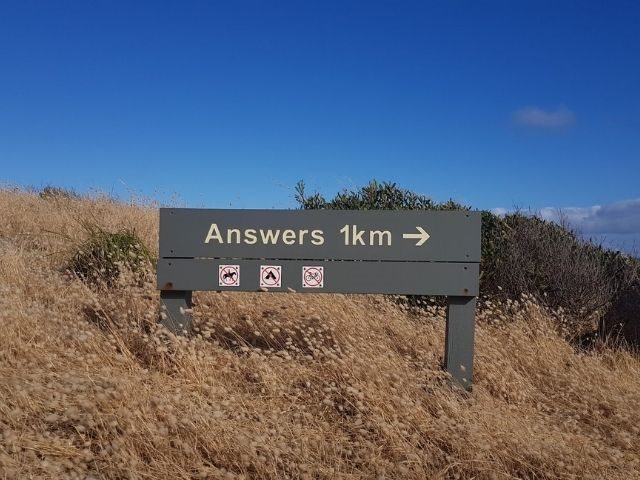 A sign that says "Answers, 1km" with a right-pointing arrow