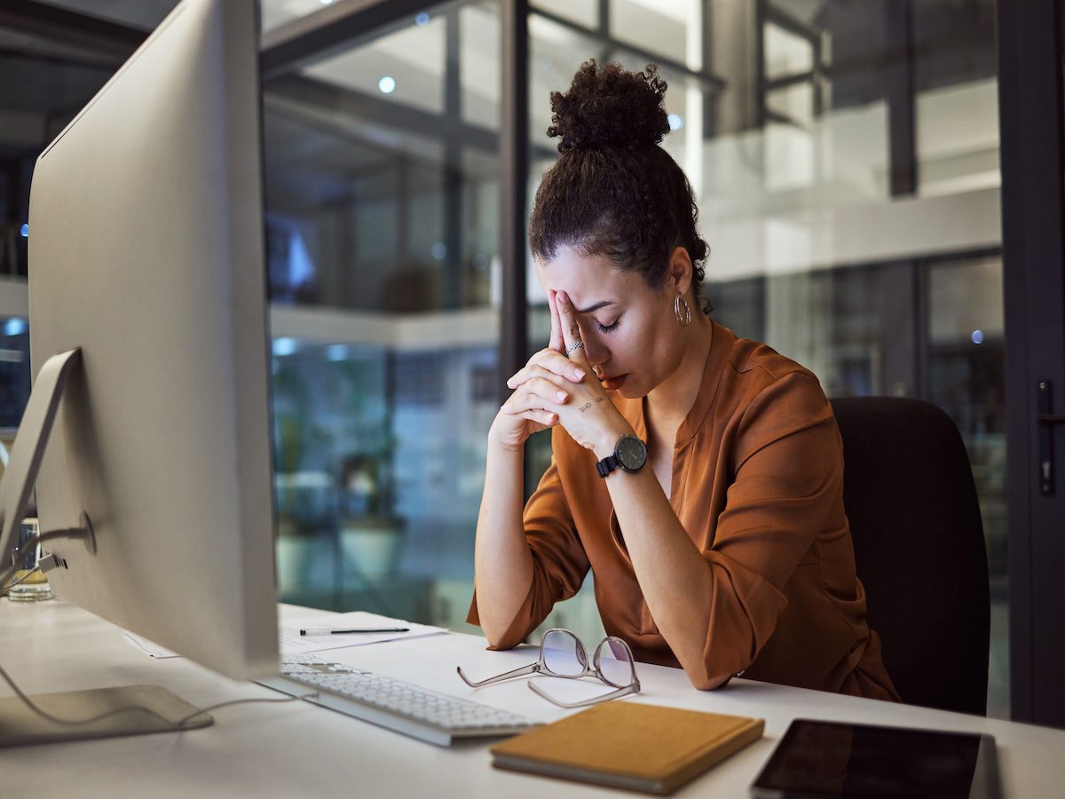 A person looking stressed out and sitting in front of a computer