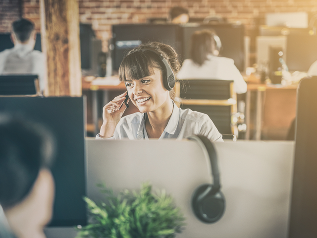 A customer support agent in an office, helping a customer on the phone. - AI customer support agent concept
