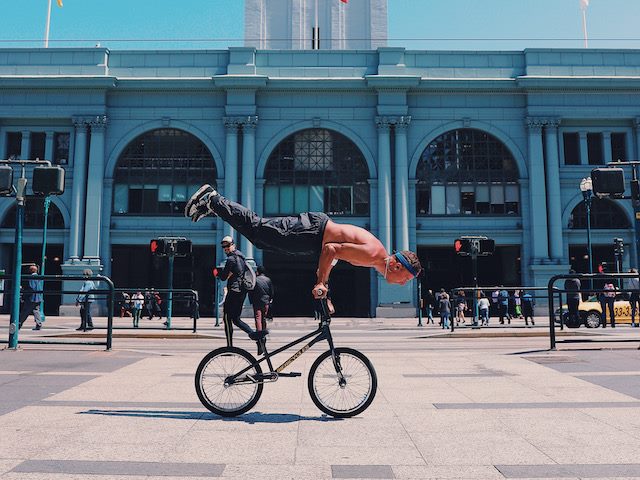 person balancing on his bicycle handlebars