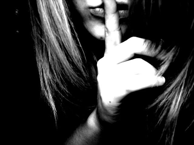 woman holding finger in front of her mouth - shhhhhhh