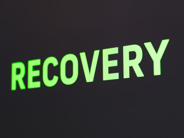 recovery spelled out in illuminated green text on a black background